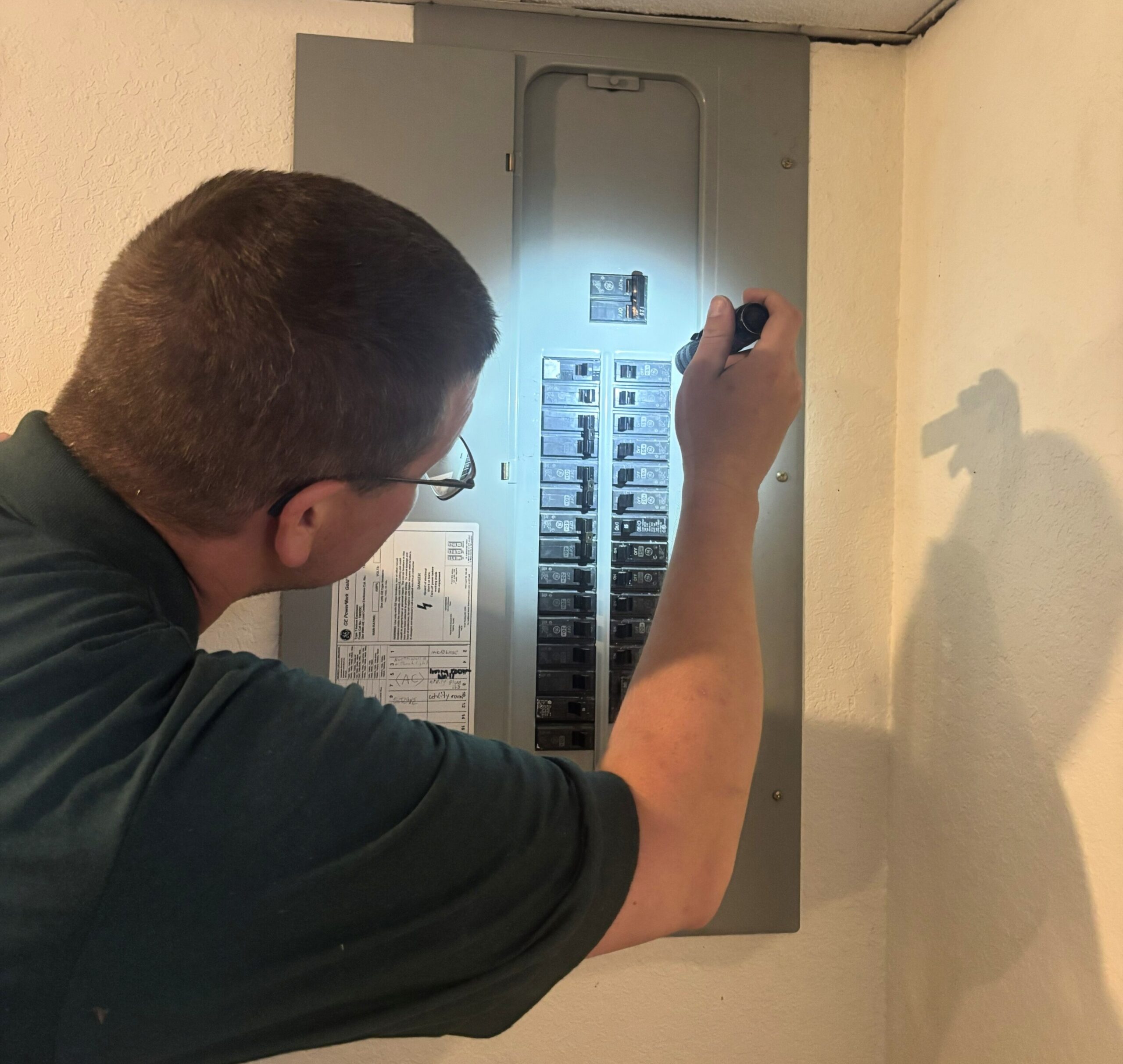 IMG_5569 cropped Professional home inspector examining a residential electrical panel during a comprehensive home inspection for Whitetail Home Inspections