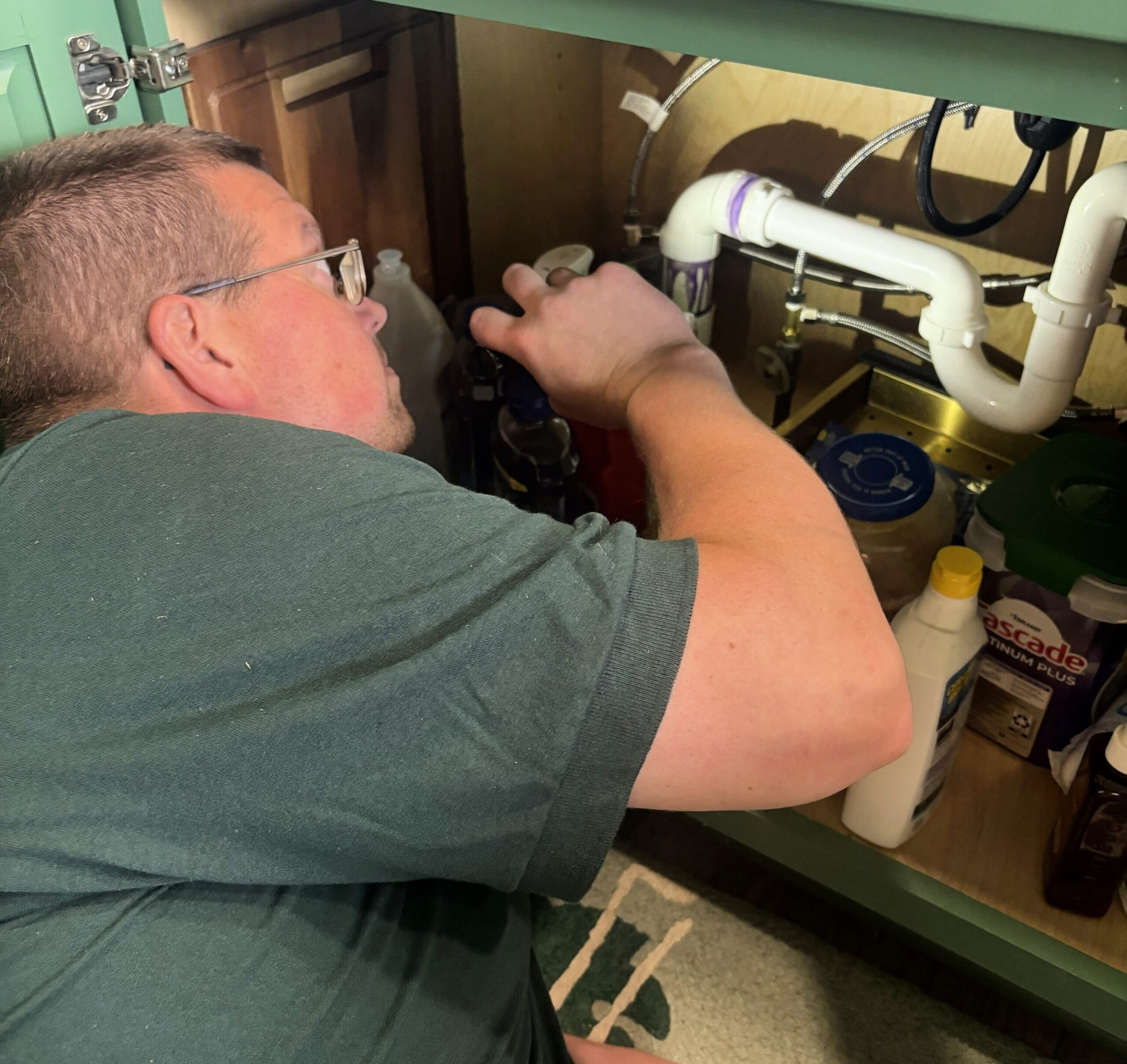 IMG_5580 Professional home inspector inspecting residential plumbing under a kitchen sink as part of a comprehensive home inspection for Whitetail Home Inspections.